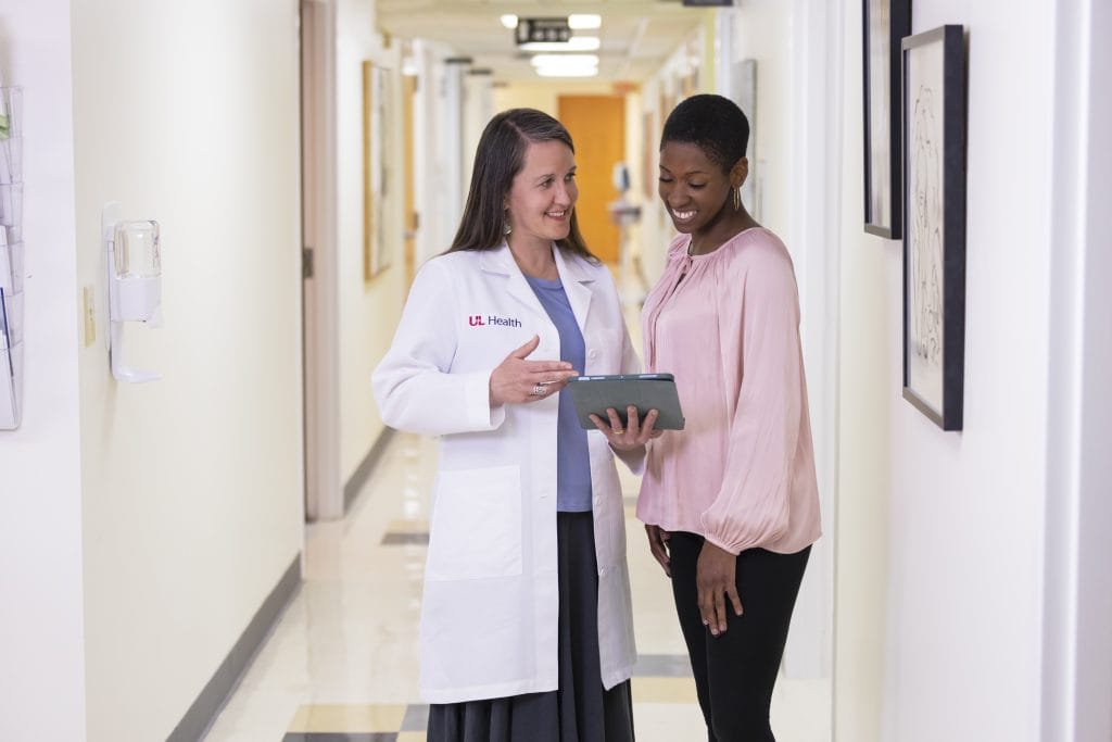 A doctor showing a woman her test results, representing the importance of Artificial heart research funding and how it can impact lives every day.